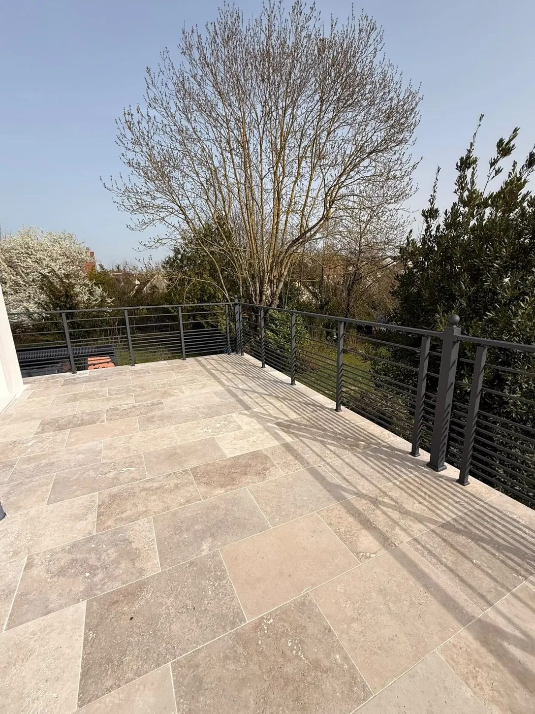 garde-corps aluminium anthracite à lisses horizontales sur une terrasse en pierre